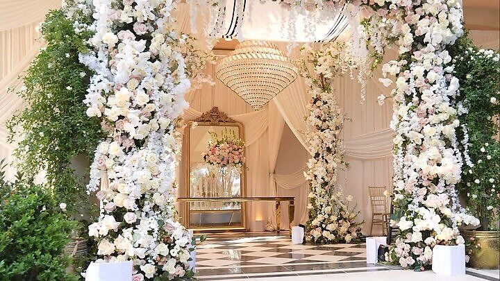 Floral wedding ceremony arch with crystal chandelier