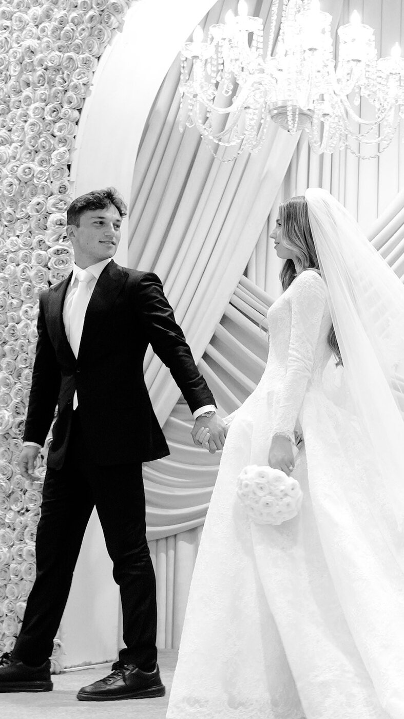Bride and groom holding hands, black and white